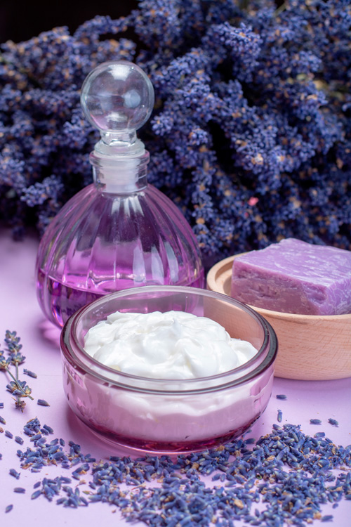 Масло, крем и мыло с лавандой, цветы лаванды на заднем фоне Крем и мыло, масло и цветы лаванды