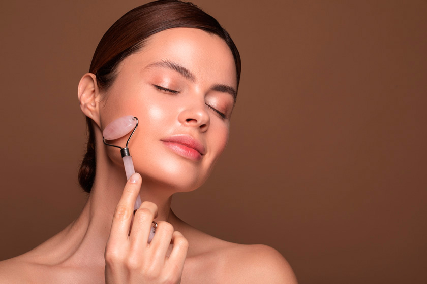 Женщина держит кварцевый массажер для лица Массаж лица с помощью стика