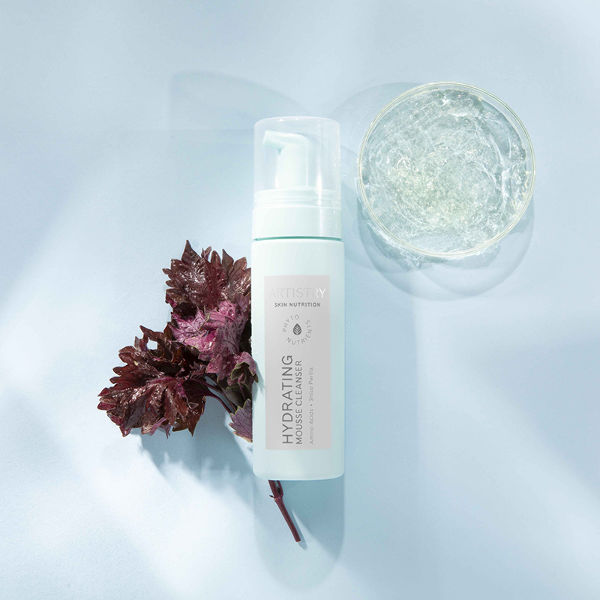 Hydrating Mousse Cleanser With Ingredients on Blue Background Artistry Skin Nutrition Stylized Product and Ingredient Photography