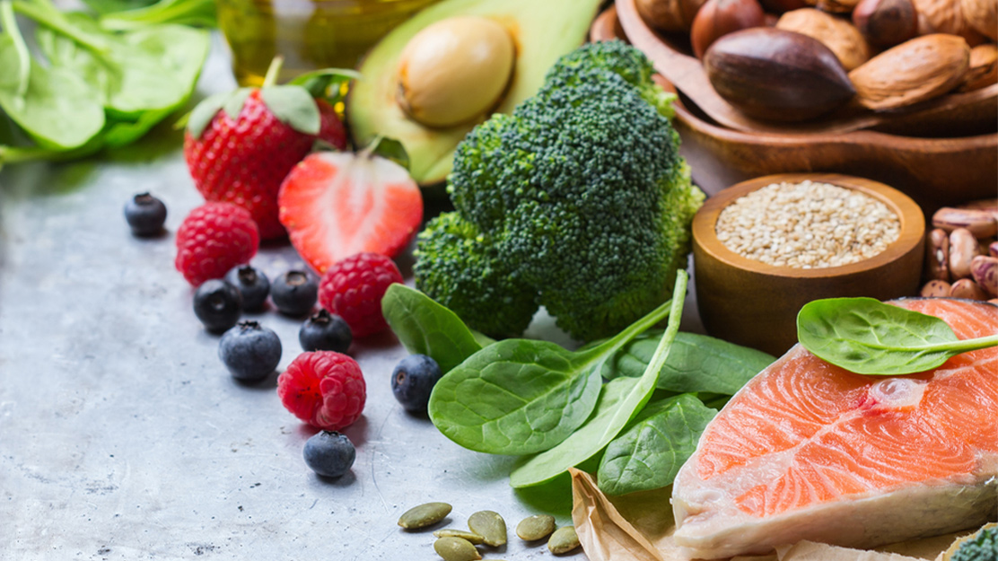 Авокадо, шпинат, форель, ягоды и другие продукты на столе